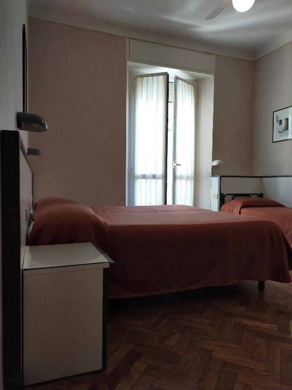 a bedroom with a large bed and a window at Affittacamere Giannina in Alassio