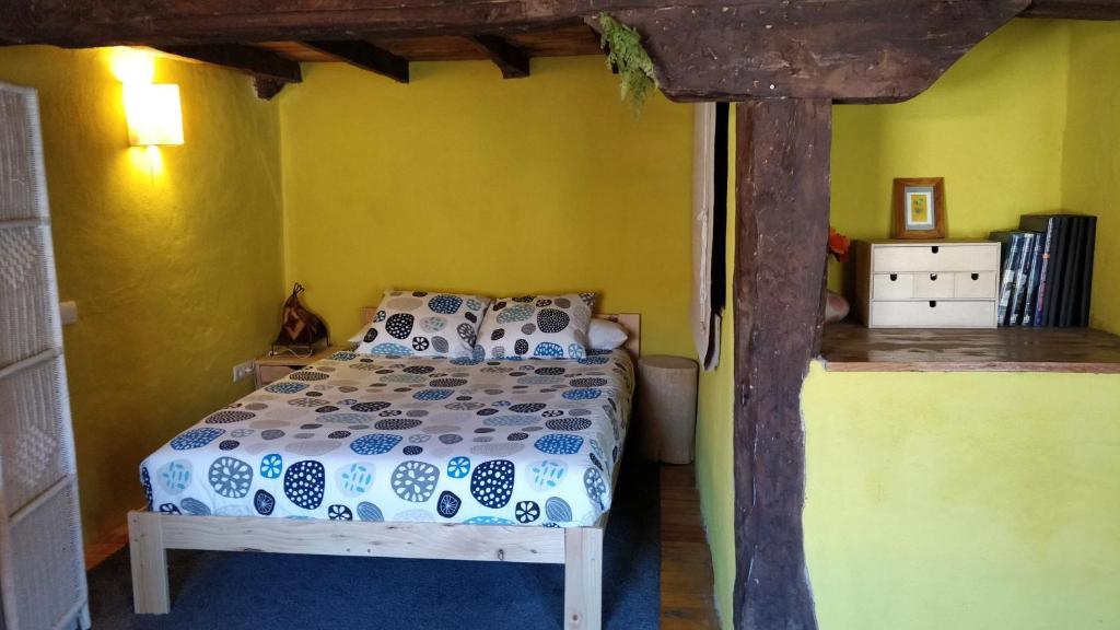 una camera con un letto in una stanza con pareti gialle di La Casa Amarilla a Olleros de Pisuerga