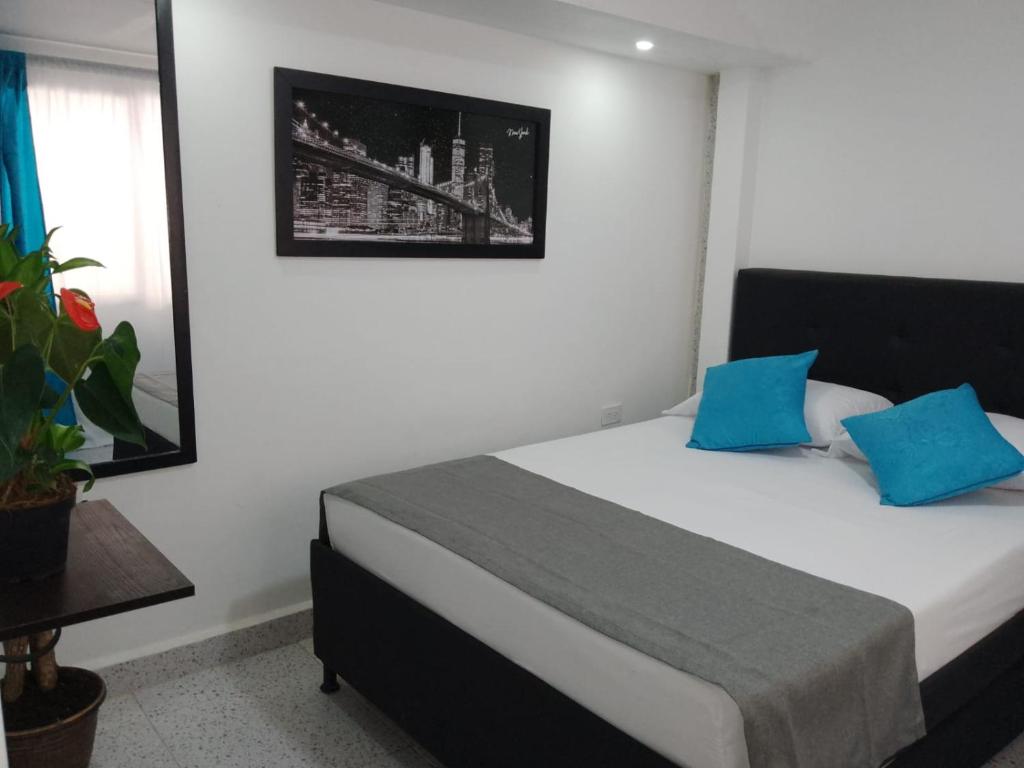 - une chambre avec un lit et des oreillers bleus dans l'établissement Hotel Villa Guatape, à Guatapé