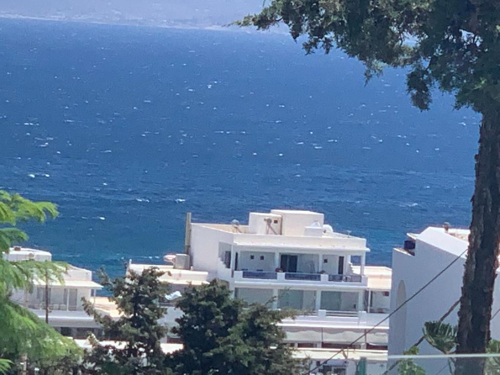 a white building with the ocean in the background at sun senses luxury Vilas Dione in Piso Livadi