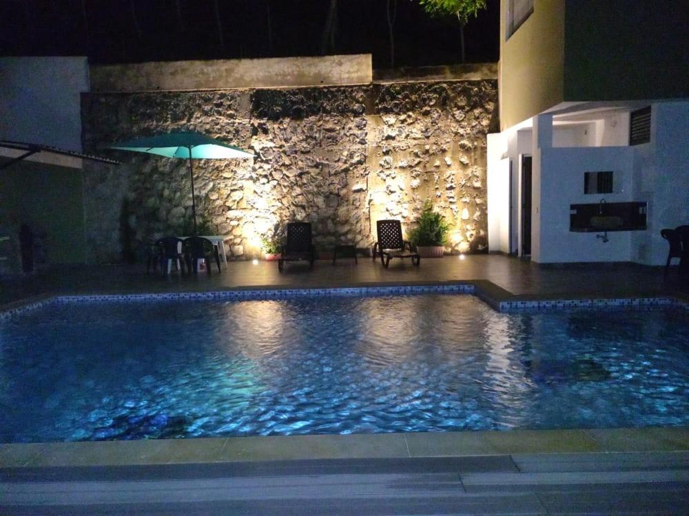 una piscina por la noche con sombrilla en FINCA LA AMISTAD, en Anapoima
