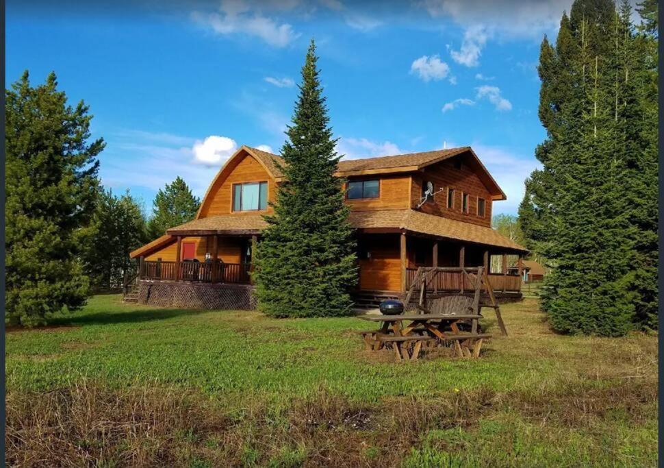 een groot houten huis met een grote tuin bij Red Cedar in West Yellowstone