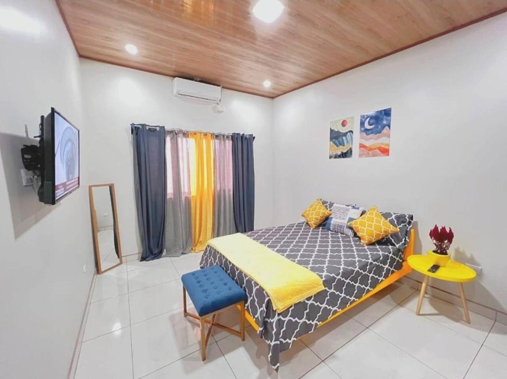 a bedroom with a bed and a table and a tv at Tuareg Place Aeropuerto AC in Alajuela
