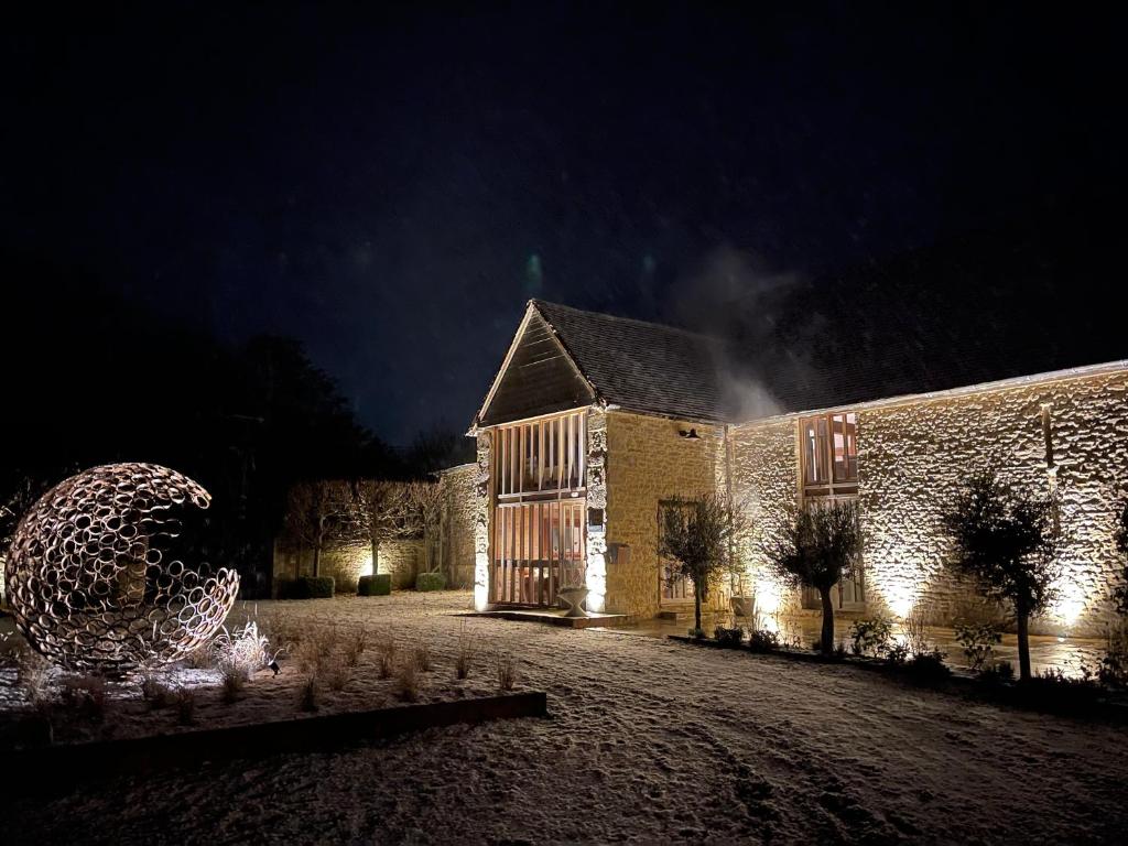 a building at night with a christmas tree in front of it at 17th Century Barn near Le Manoir aux Quat’Saisons in Great Milton