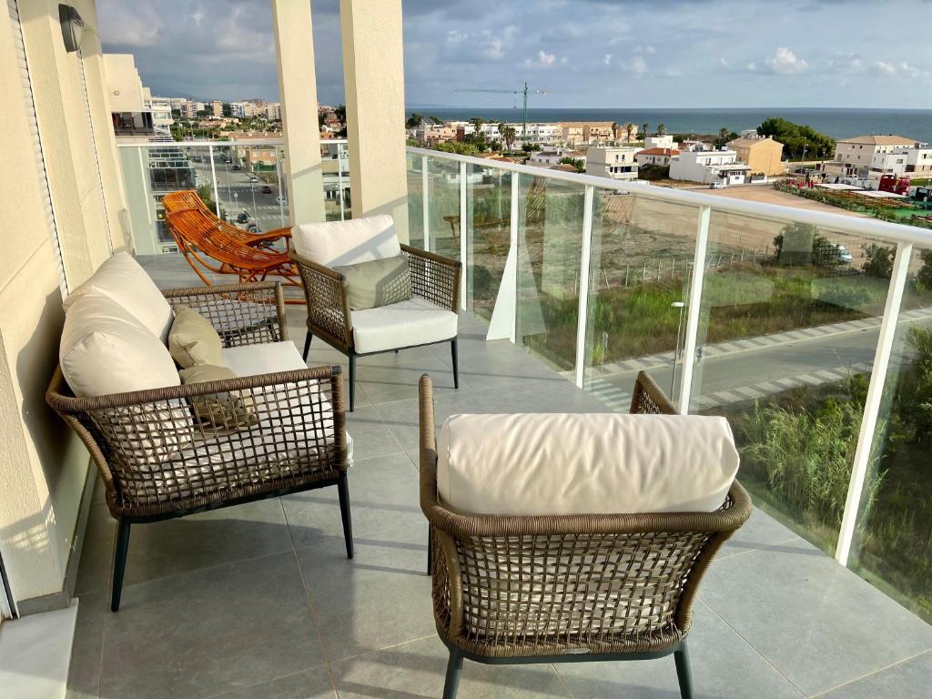 balcone con 2 sedie e divano. di Beautiful penthouse with pool and wonderful beach view a Oliva