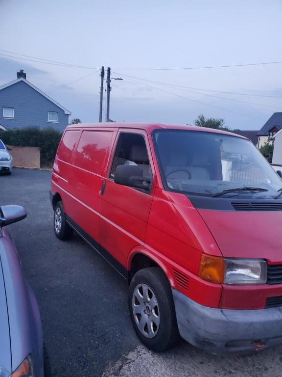 a red van parked in a parking lot at VW Campervan in Pembrokeshire