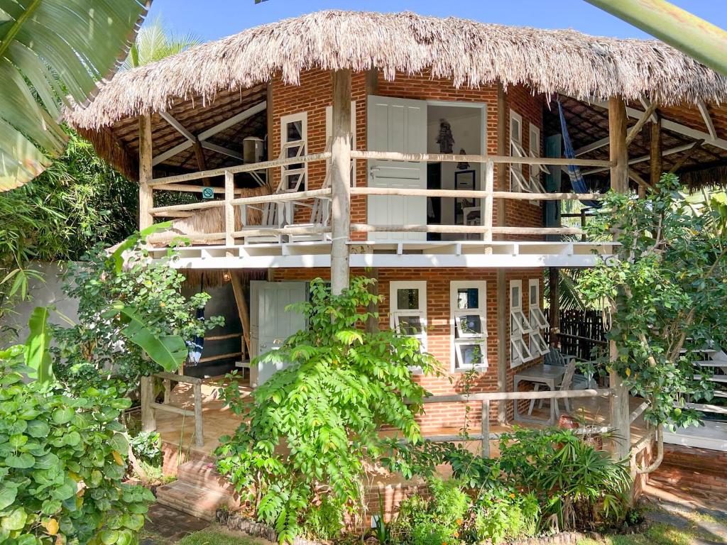 a bamboo house with a thatched roof at Casa Zulu Umoya in Icaraí