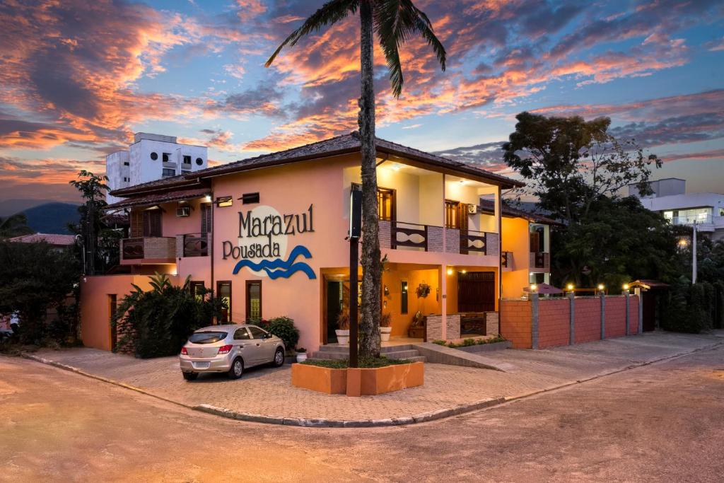 a building with a car parked in front of it at Pousada Mar Azul in Ubatuba