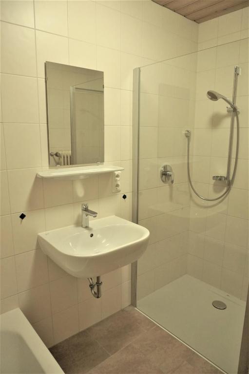 a white bathroom with a sink and a shower at Pranger Hof in Trins