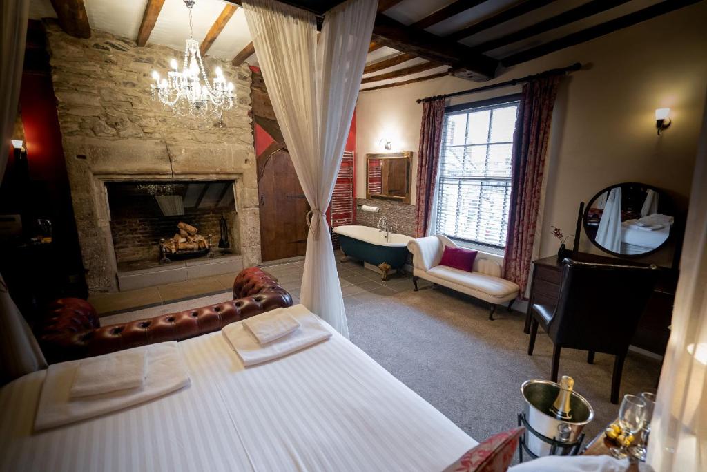 a room with a bed and a fireplace and a tub at Caravelli in Loughborough