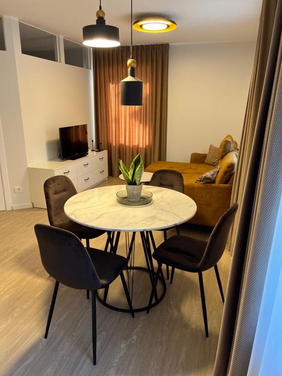 a dining table and chairs in a living room at Bell Tower Apartment in Plungė