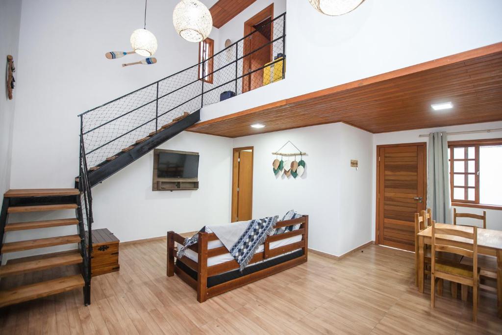 uma sala de estar com uma escada e uma sala de jantar em Casa em Balneário Camboriú na Praia do Estaleiro no Balneário Camboriú