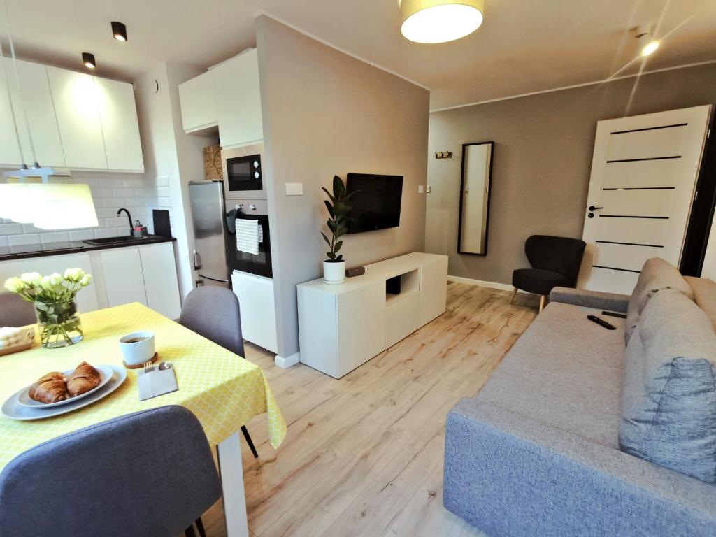 ein Wohnzimmer mit einem Sofa und einem Tisch in der Unterkunft Nowoczesny apartament w sercu Wrocławia in Breslau