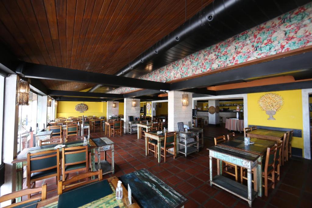 un restaurant vide avec des tables et des chaises en bois dans l'établissement Delphin Beach Hotel, à Guarujá