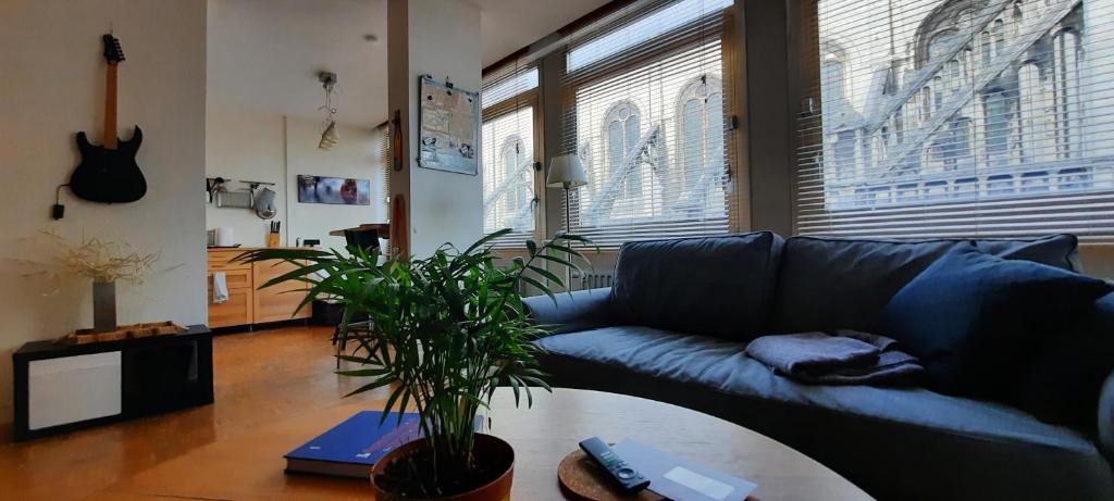 ein Wohnzimmer mit einem blauen Sofa und einem Tisch in der Unterkunft St Catherine - Sweet home - Bxl - Studio Apartment with city view in Brüssel