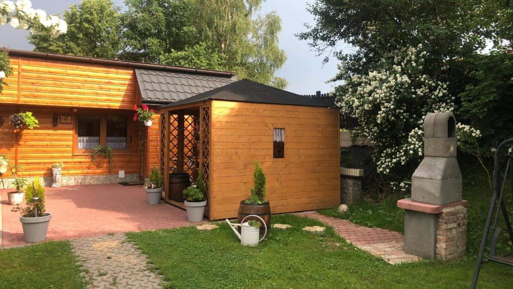 mała drewniana kabina z dziedzińcem przed nią w obiekcie Apartamenty u Baców w mieście Ostrowsko