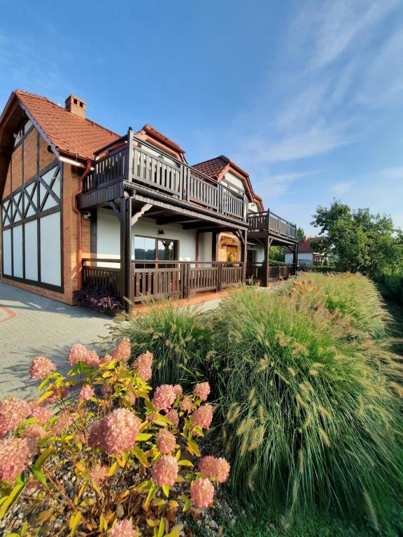 a house with a deck and some plants at Uroczysko Lutówko in Sępólno Krajeńskie