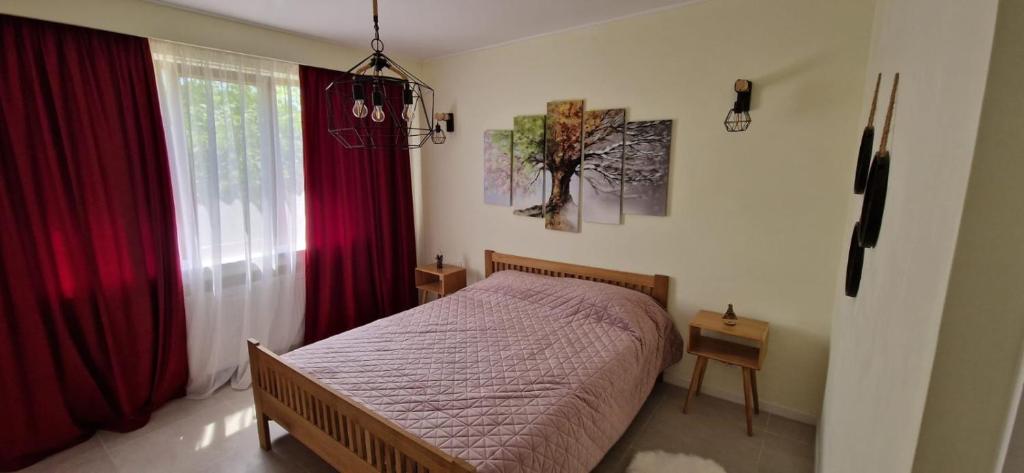 a bedroom with a bed and red curtains at University Apartment in Baia Mare