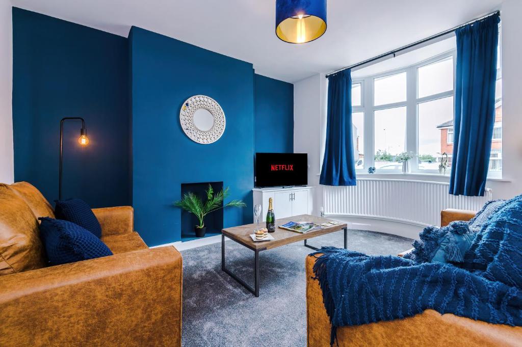 a living room with blue walls and a couch and a table at Pristine 3-bed home in Crewe by 53 Degrees Property, ideal for Business & Contractors, Great Parking - Sleeps 5 in Church Coppenhall