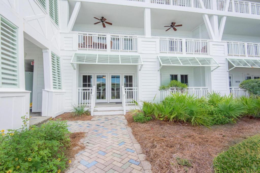 a white house with two balconies and plants at Watercolor Townhouse 9 in Seagrove Beach