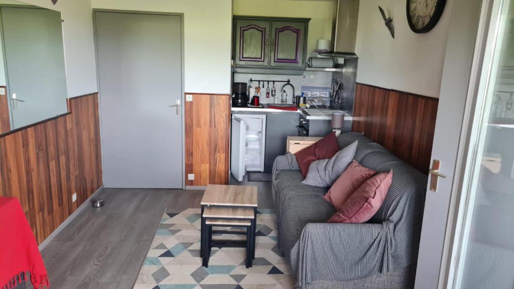 een woonkamer met een bank en een tafel bij Appartement en bord de mer in Villers-sur-Mer