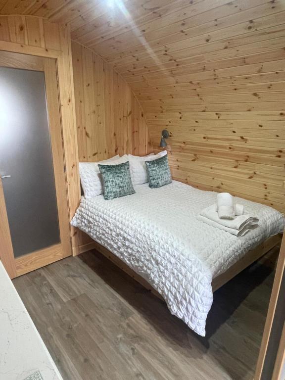 a bedroom with a bed in a wooden cabin at Allt Yelkie Pod Aon, Earlish in Earlish