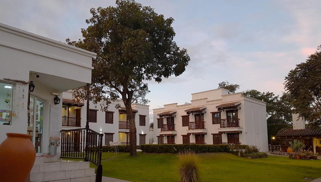 un gran edificio blanco con un árbol en el patio en Posada de los Poetas Hotel Boutique en San Lorenzo