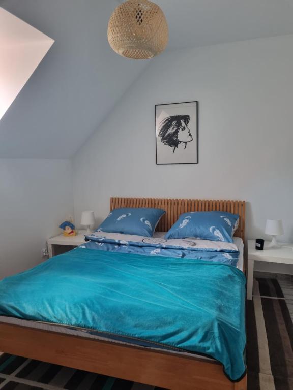 1 dormitorio con 1 cama con edredón azul en CZEKOLADA Apt., en Krynica-Zdrój