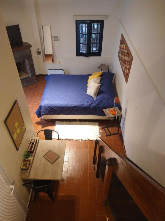 a small bedroom with a bed and a table at Azules de Abril in Yerba Buena