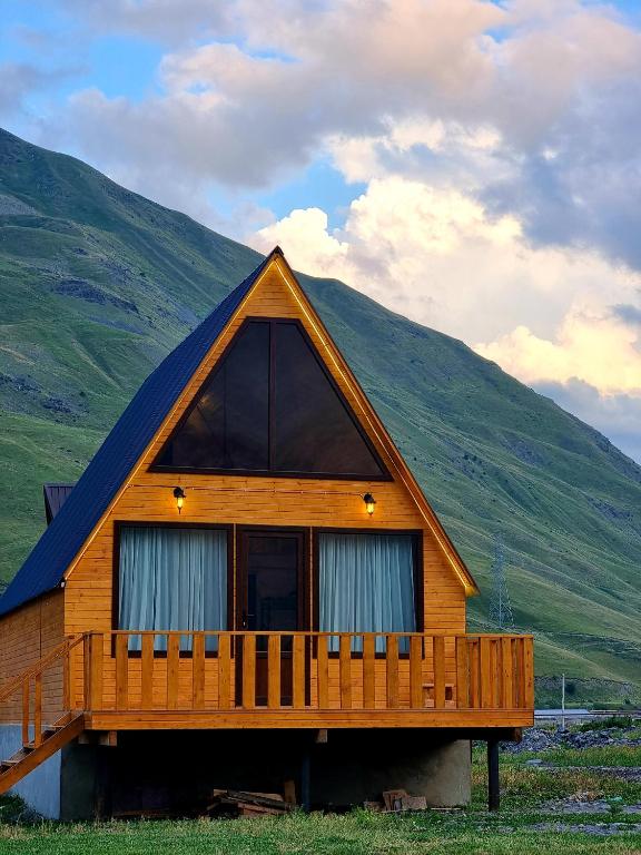 ein großes Holzhaus mit einem Gamer-Dach in der Unterkunft Mountain hut in Kazbegi in Kazbegi