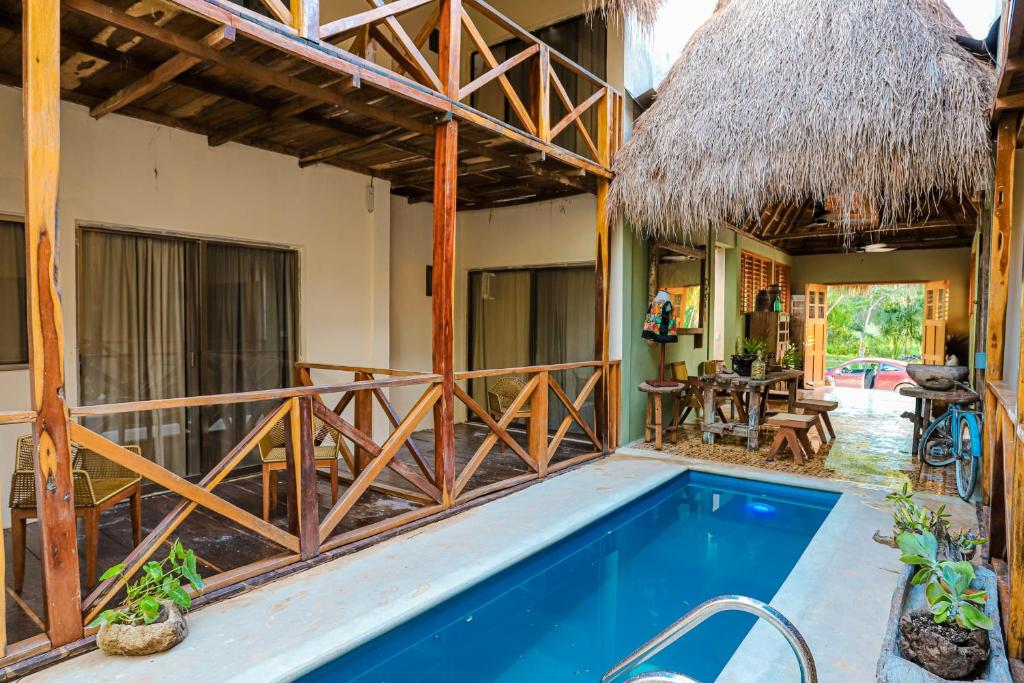 a house with a swimming pool and a thatched roof at Alma de Zorro in Bacalar