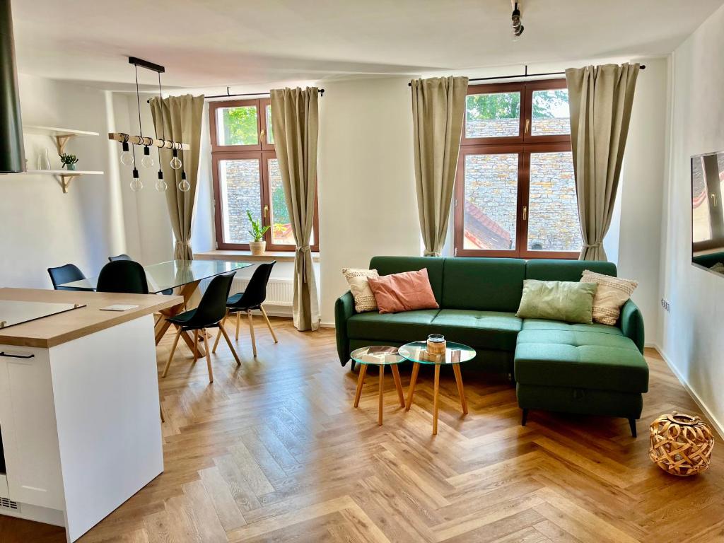 uma sala de estar com um sofá verde e uma mesa em Apartmán Elen em Nové Město nad Metují