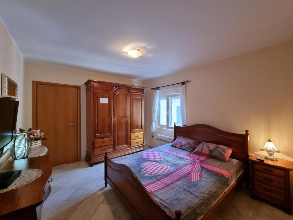 a bedroom with a bed with a dresser and a window at lovely apartment on the sea shore, with a view and free Wi-Fi in Kotor