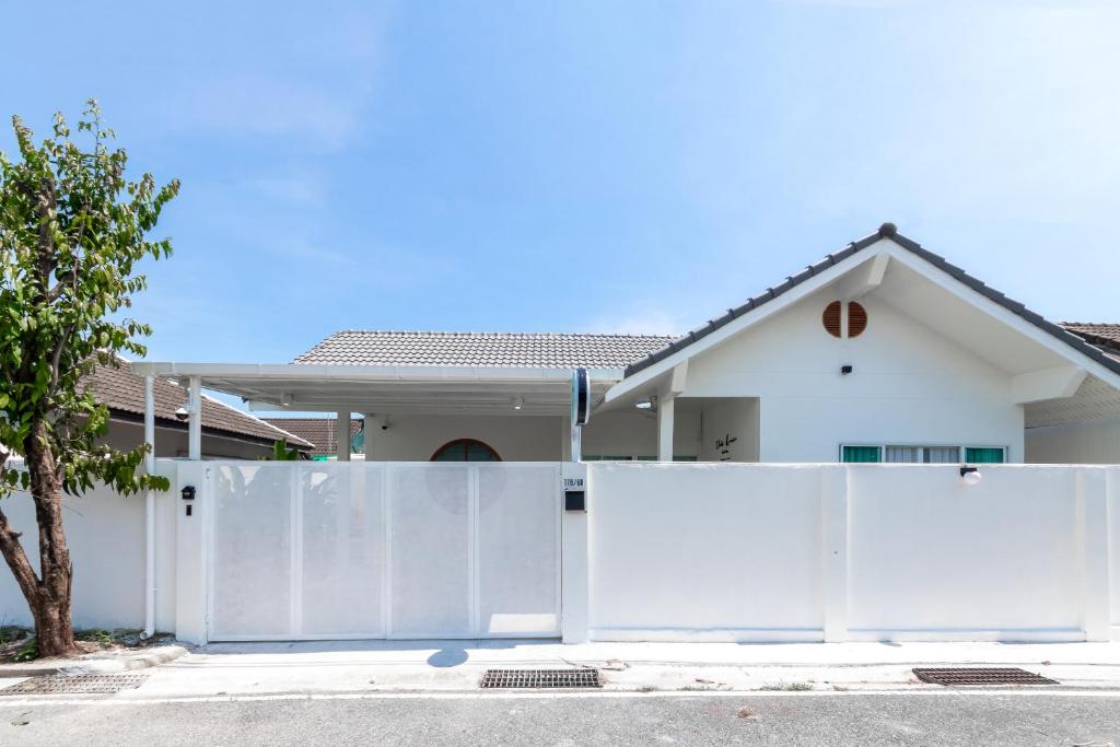 une clôture blanche devant une maison dans l'établissement Ther house Banchang, à Ban Chang