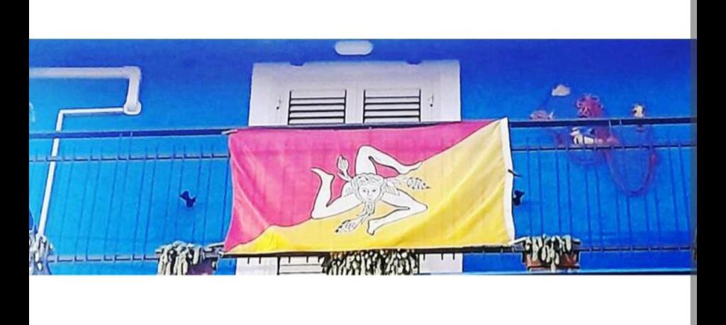 a flag hanging on the side of a building at SABRINA'S HOUSE in Giardini Naxos