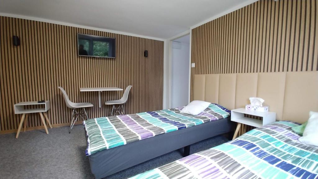 a bedroom with two beds and a table and chairs at Noclegi Malta Poznań in Poznań