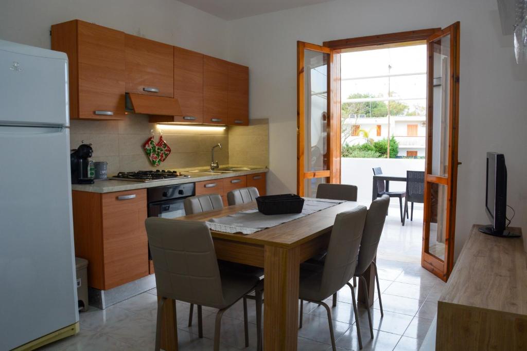 una cucina e una sala da pranzo con tavolo e sedie in legno di Adriatic Suite - Casa vacanze a SantʼAndrea