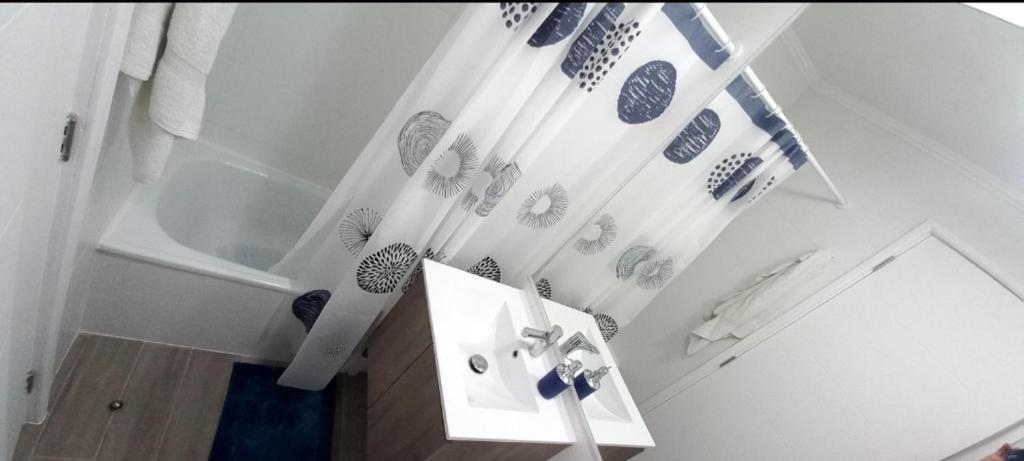 y baño con bañera y cortinas de ducha azules y blancas. en Pucon villarrica en Pucón