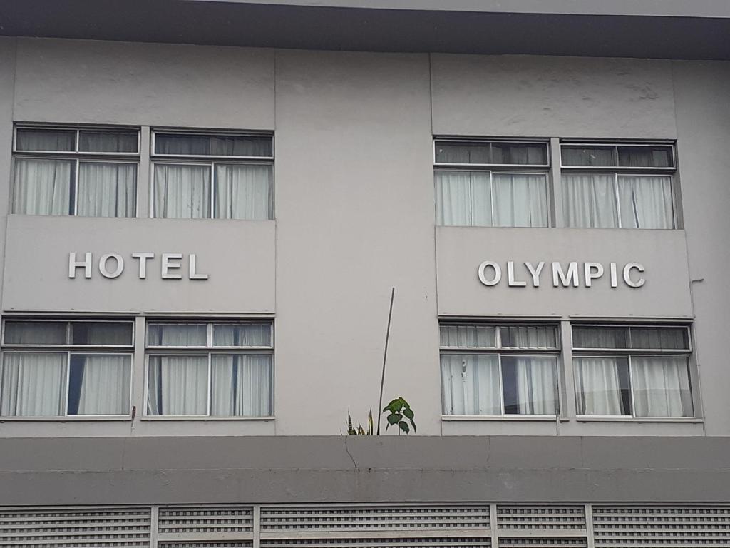 un hotel con las palabras hotel y solo migrar en la fachada en Hotel Olympic, en Port Vila
