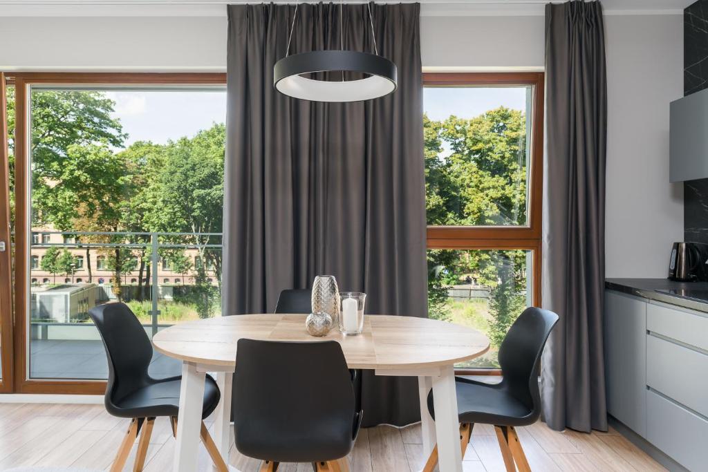 a dining room with a table and chairs in front of a window at Bookowska Apartments in Poznań