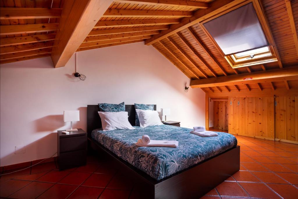 um quarto com uma cama num quarto com tectos em madeira em Casa Vereda, Ponta Delgada, S. Miguel em Ponta Delgada