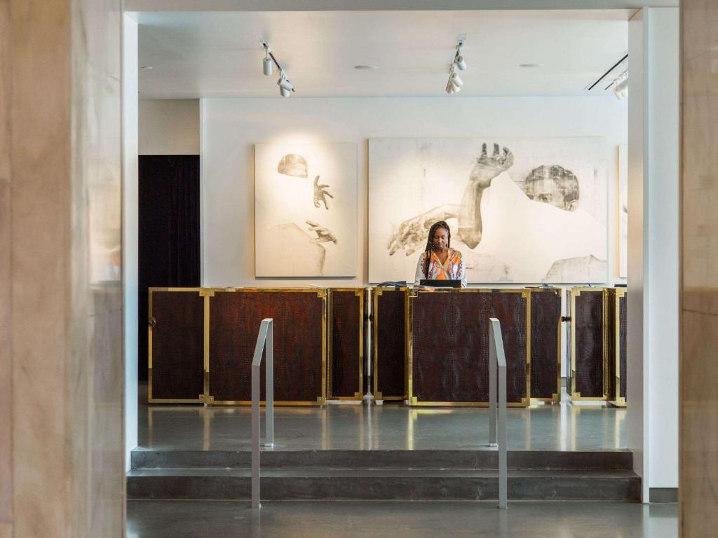 una mujer parada en un podio en una habitación con arte en las paredes en 21c Museum Hotel Lexington, en Lexington