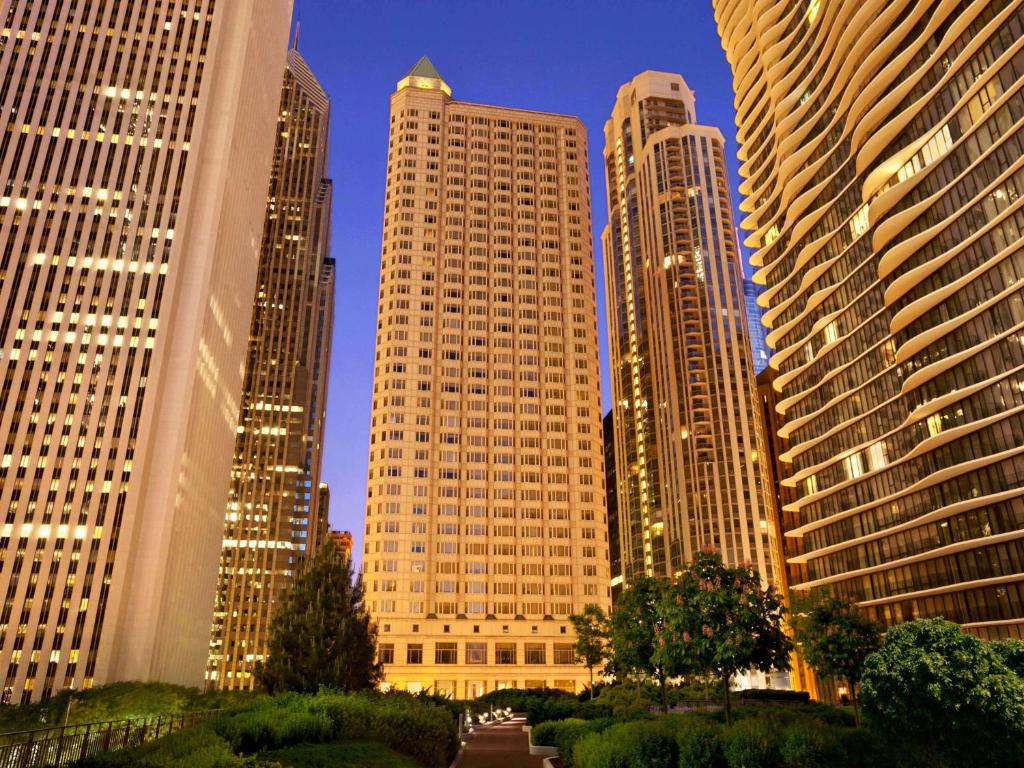 un grupo de edificios altos en una ciudad por la noche en Fairmont Chicago Millennium Park en Chicago