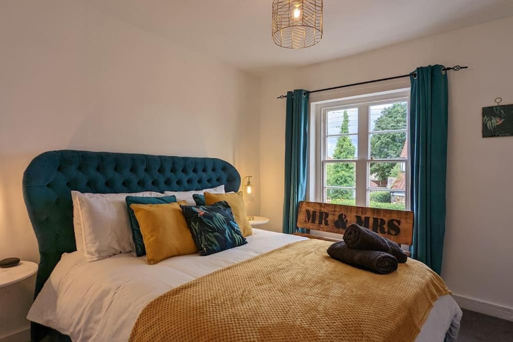 a bedroom with a large bed with a blue headboard at Bluebell cottage Branston Lincoln in Branston