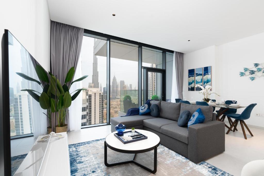 uma sala de estar com um sofá e uma mesa em Ultimate Stay / 4 Beds / Burj Khalifa View / Ultra Modern / Business Bay no Dubai