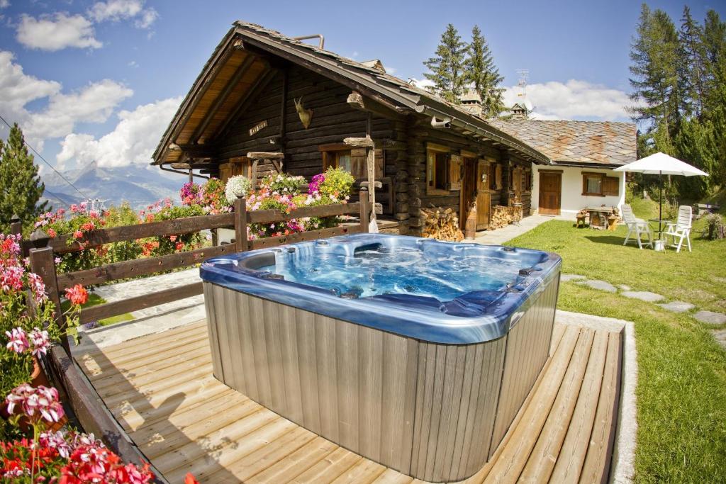 a hot tub on a deck in front of a house at Chaletbethere in Pila