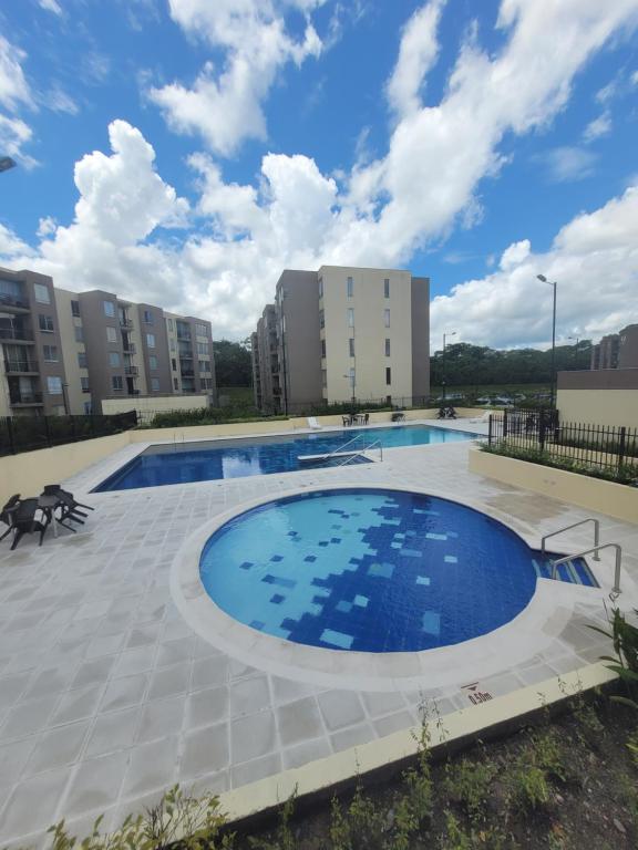 una gran piscina en un patio con edificios en Encantador y acogedor apto amoblado villavicencio, en Villavicencio