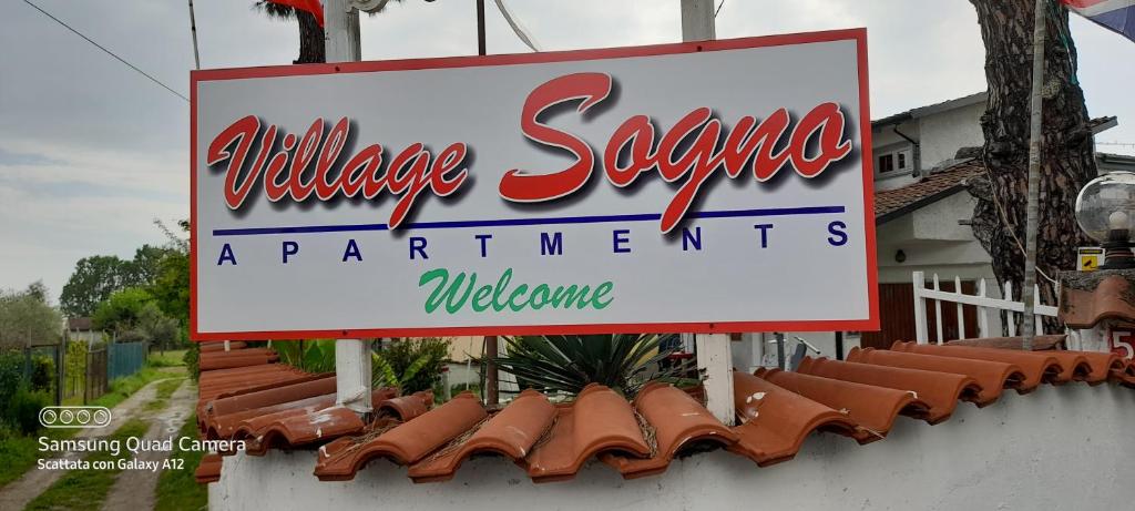 a sign for a walt disney springs apartmentments welcome at Village SOGNO in Massa