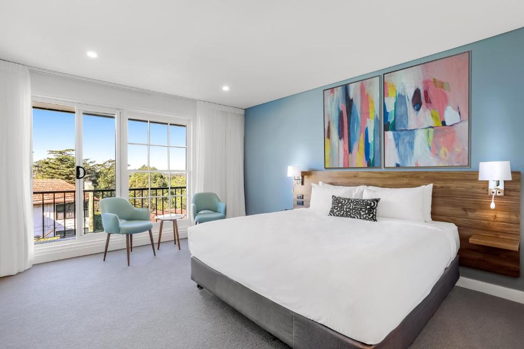 a bedroom with a large bed and a large window at Killara Hotel & Suites in Killara