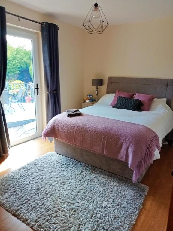 a bedroom with a bed and a large window at Mary's place in Castlewellan